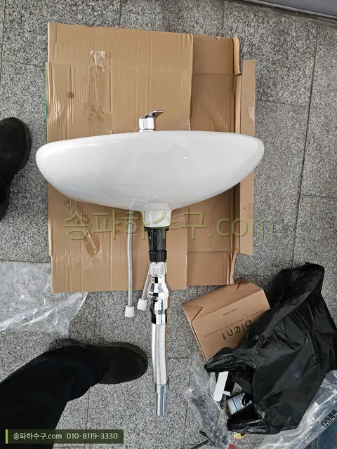 새 세면기와 부속 설치 준비