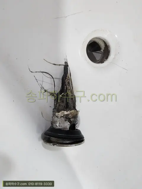 팝업 마개에 엉킨 머리카락 근접