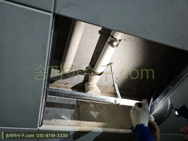 천장 점검구 안의 배관을 점검하는 모습