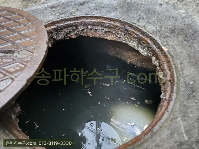 정화조 앞 오수관 맨홀을 열고 흐름을 확인하는 장면